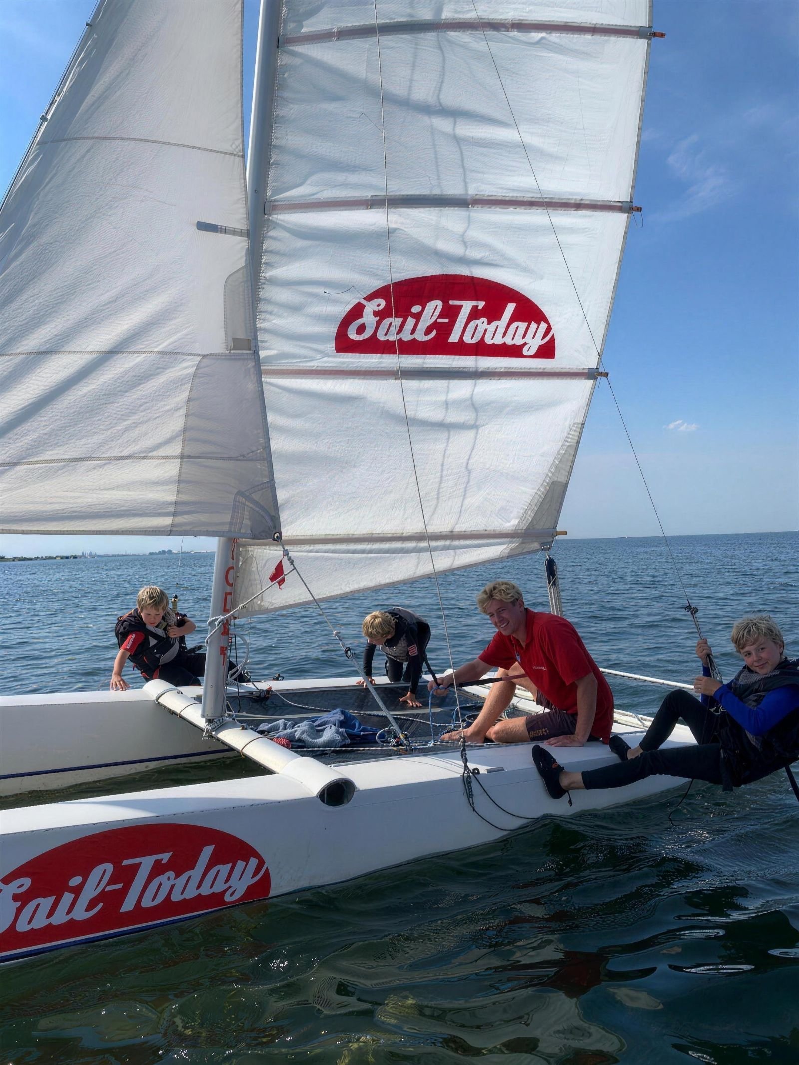 Jongeren aan boord van een catamaran tijdens de Laser Bug & catamaran cursus